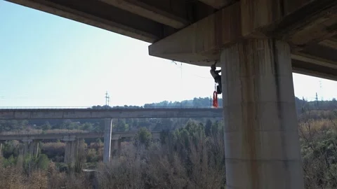 Rope access technician climbing bridge concrete pillar Stock Footage 306582118