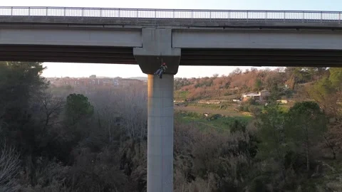 Rope access technician inspecting bridge pylon Stock Footage 306582110