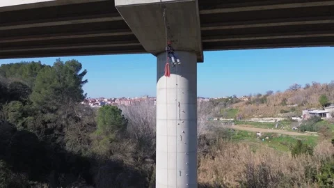 Rope access technician inspecting bridge pylon Stock Footage 306919378