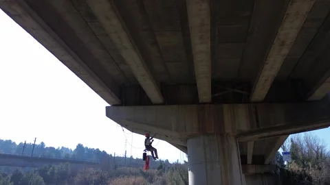 Rope access technician inspecting highway overpass concrete structure Stock Footage 306758231