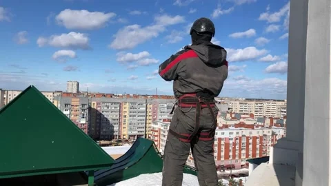 Rope access technician makes a phone call outside Stock Footage 235902893
