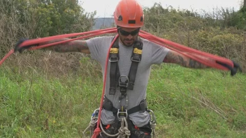 Rope access technician preparing climbing rope for tree pruning Stock Footage 302161883