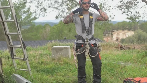 Rope access technician preparing equipment for tree pruning Stock Footage 302246650