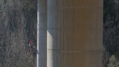 Rope access technician working on bridge pylon Stock Footage 306582583