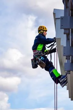 Rope access worker hanging from wall residential building during high-rise wo Stock-Fotos