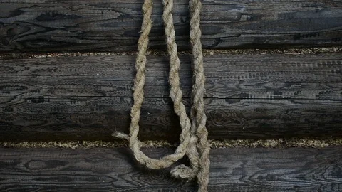 Rope against the background of a log wall, removes the rope, hangs the rope Stock Footage 117046801