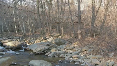 A rope bridge over a mountain stream Stock Footage 234927835