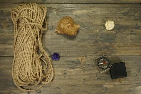 Rope, compass and snail seashell on a wooden table Stock Photos
