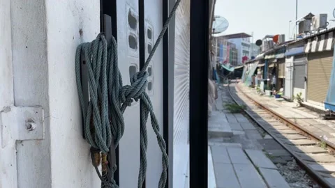Rope cord hanging on wall pulls outdoor umbrella at local Maeklong market Stock Footage 196620489