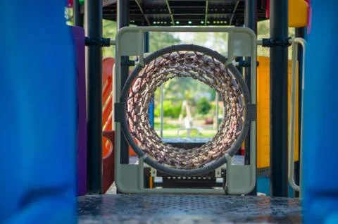 Rope crawl pipe labyrinth on modern kids playground Foto stock