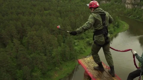 Rope jumping from high mountains, over the river Stock Footage 76487606