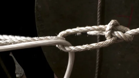 Rope knot being threaded around large metal object 스톡 동영상 123728701
