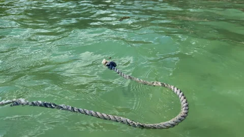 Rope swing over the crystal clear waves. Ripple In the water Stock Footage 303489594