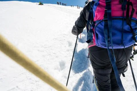 Rope team member point of view with mountaineers walking on snow and ice in Stock Photos