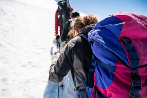 Rope team member point of view with mountaineers walking on snow and ice in s Stock Photos