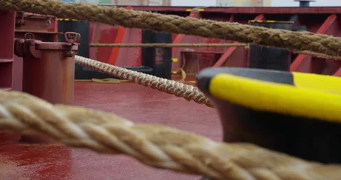Ropes along with heavy anchor chain lie across wet deck Stock Footage 321775545