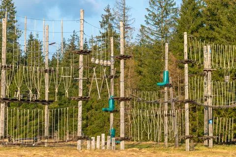 A ropes course stands in a clearing, surrounded by forest. outdoor adventure  Stock Photos