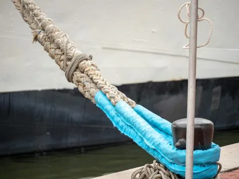 Ropes from ship using marine bollards rope to anchor to dock Stock Photos