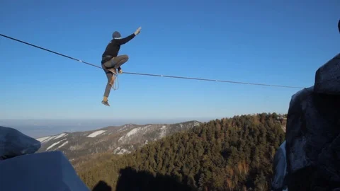 Ropewalker poised over the abyss. Video stock 83673521
