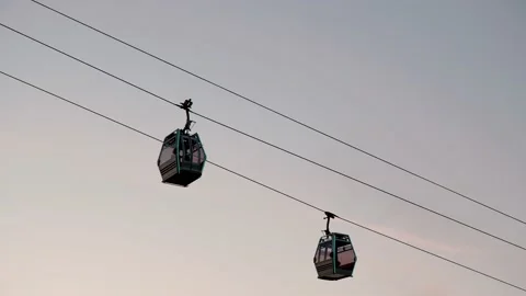 Ropeway, cable car cabin move towards each other against backdrop of sunset sky Stock Footage 224584904