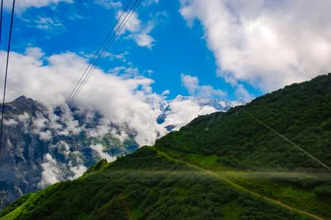 Ropeway in the swiss alps. View from the cable car on green hills and mountains Фото