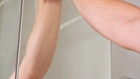 Ropped view man wiping mirror with rag, standing bathroom. Householder make Stock Footage 246641364