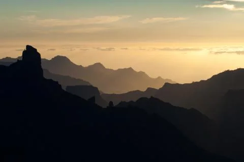 Roque Bentaiga to the left and cliffs of the west of Gran Canaria at sunset Stock Photos