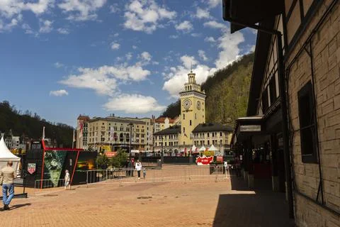 Rosa Khutor. The clock tower on the central square. Town hall. People walk ar Stock Photos