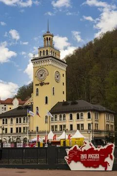 Rosa Khutor. The clock tower on the central square. Town hall. People walk ar Stock Photos