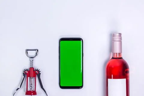 Rose and with corkscrew on white table. Mockup phone. Red wine and steel wine Stock Photos