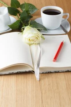 Rose and empty notebook page on wood background Stock Photos