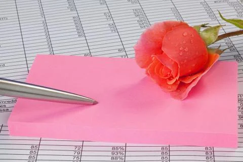 Rose and notepad on a spreadsheet Stock Photos