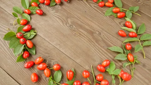 Rose hips with leaves on a board. 스톡 동영상 328441193