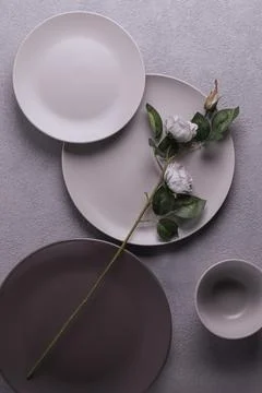 Rose on plates on a gray table. Bed tones. a concept for a restaurant or a love Foto stock