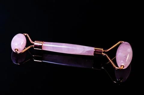 Rose quartz facial roller and massage stone gua sha isolated on white backgro Stock Photos