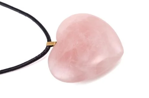 Rose quartz heart with leather string on white Stock Photos