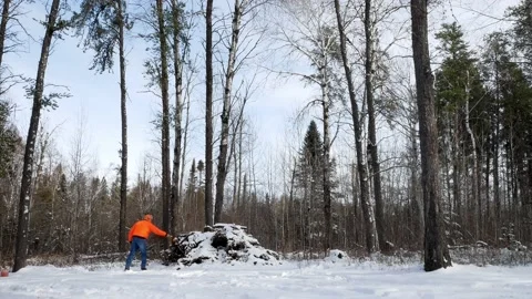 ROSEAU CO, MN - 10 NOV 2019: Man wearing hunter orange lights a fire Stock Footage 130880853