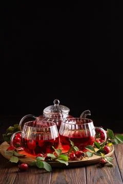 Rosehip tea set for two with fresh berries and leaves on a wooden tray Foto stock