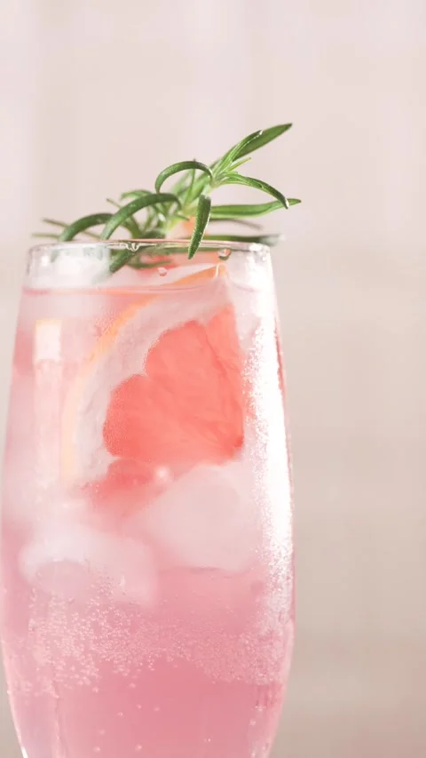 Rosemary falling into a glass of grapefruit refreshing lemonade, close up, .. Stock Footage 311004153