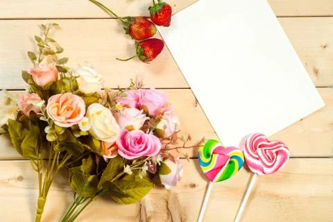 Roses flowers and empty tag for your text with heart-shaped candy on wooden b Stock-Fotos