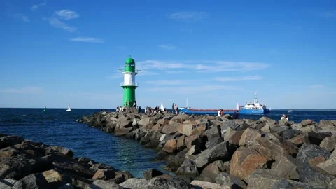 Rostock port. Lighthouse with container ship and sailboats. People. July 2022 Stock Footage 202258478