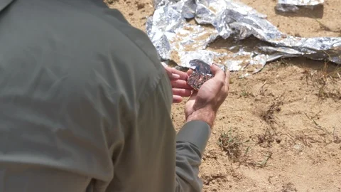 Roswell UFO crash site - Man inspects unusual alien crash debris Stock Footage 114440887