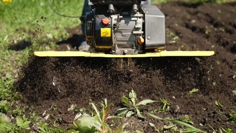 Rotary mini tiller plows arable land, slow motion. Stock Footage 205026779