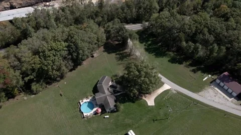 Rotate around house in a field with swimming pool and barn i Stock Footage 294040887