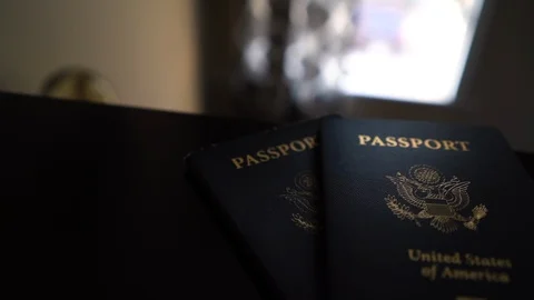 Rotate Around Light from Window Hitting Two American Passports on Dresser Stock Footage 96044500