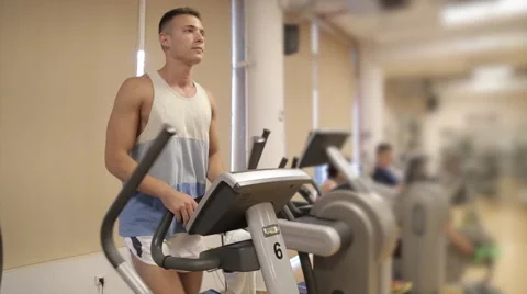 Rotate around man on elliptical machine Stock Footage 63260024