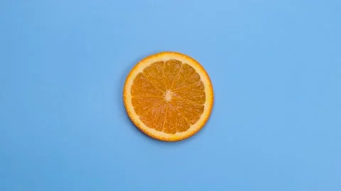 Rotate half orange isolated on blue background Stock Footage 197484360