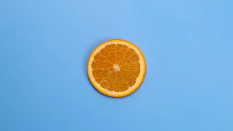 Rotate half orange isolated on blue background Stock Footage 268486703