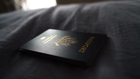 Rotate Left Around Light Hitting an American Passport on Bed Stock Footage 96044310