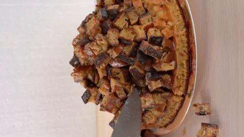Rotate the plate with the cake and start to cut with a knife. Vertical shot Stock Footage 129251843
